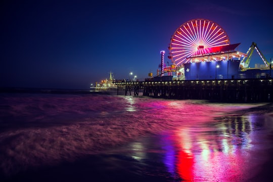 photo of ferris wheel near body of water during nighttime in Palisades Park United States