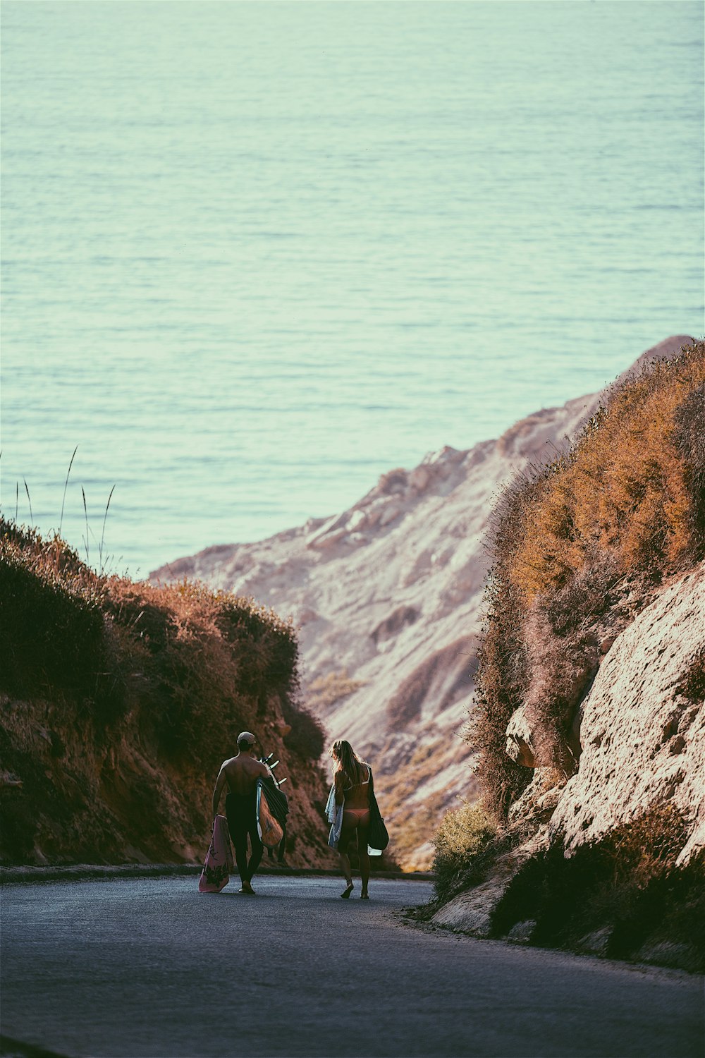 man and woman walking near rock formation