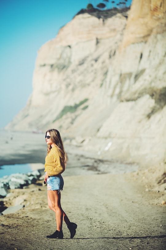 selective focus photo of woman standing near mountain in Black's Beach United States