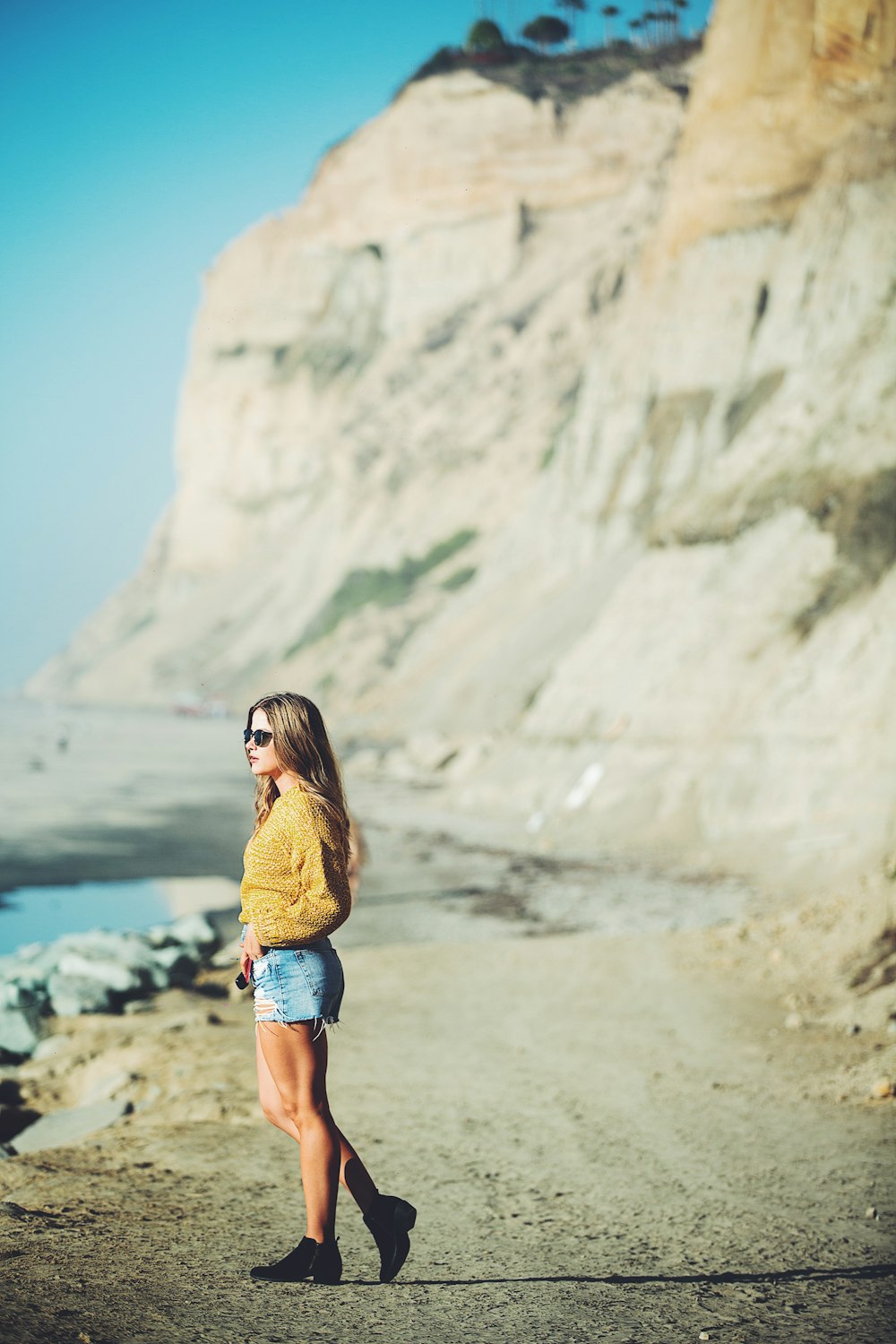 selective focus photo of woman standing near mountain