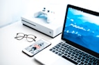turned on MacBook Pro beside iPhone and Xbox One Slim