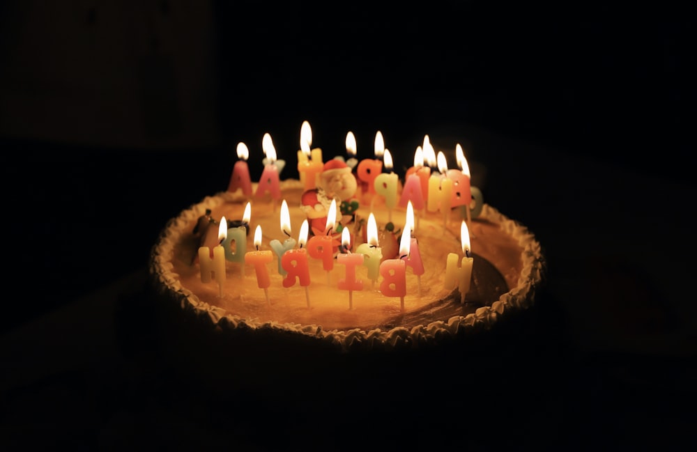 케이크에 불이 켜진 다양한 색상의 생일 촛불