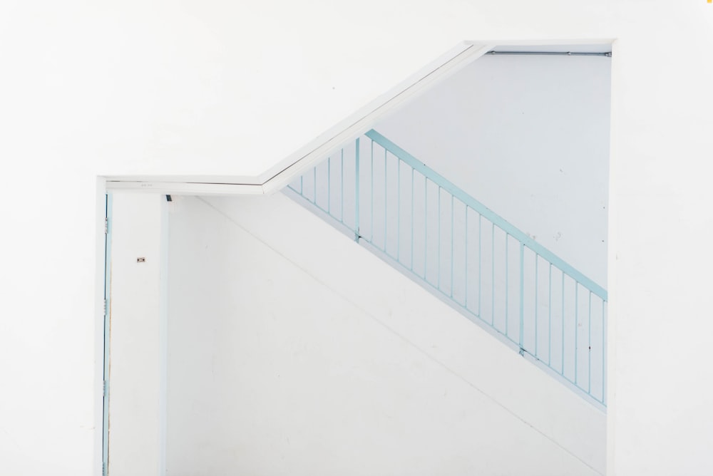 Porte en bois blanc à côté de l’escalier bleu