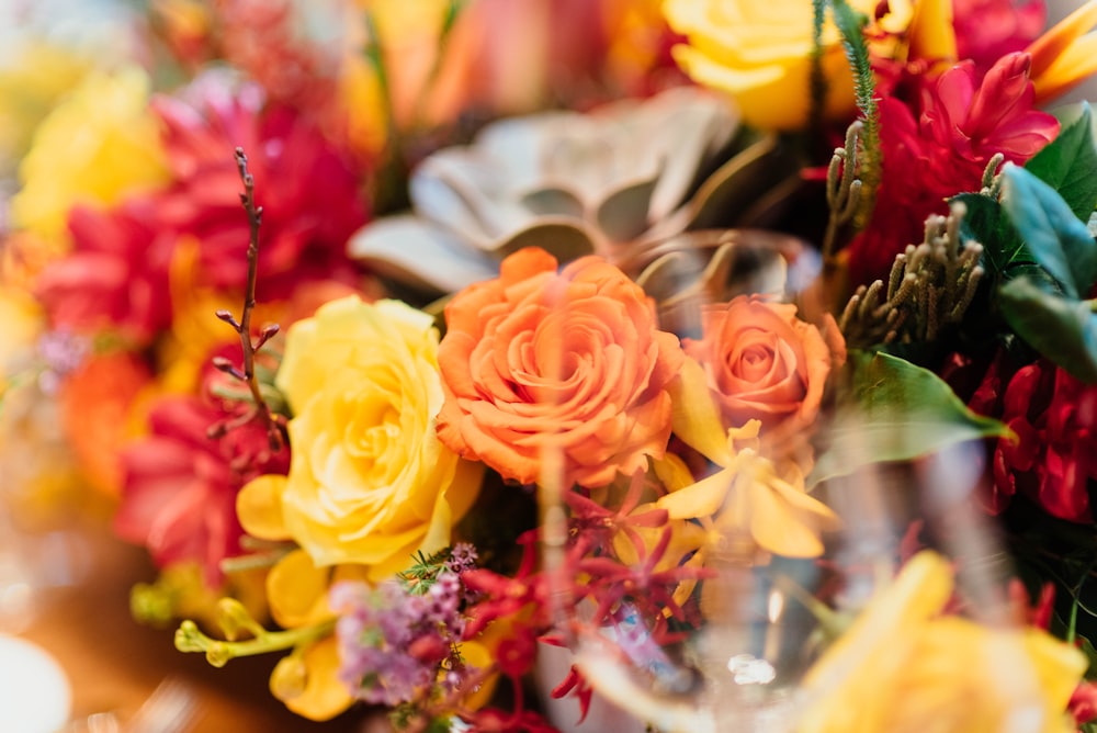 Fotografia de foco seletivo de buquê de flores vermelhas, amarelas e laranjas