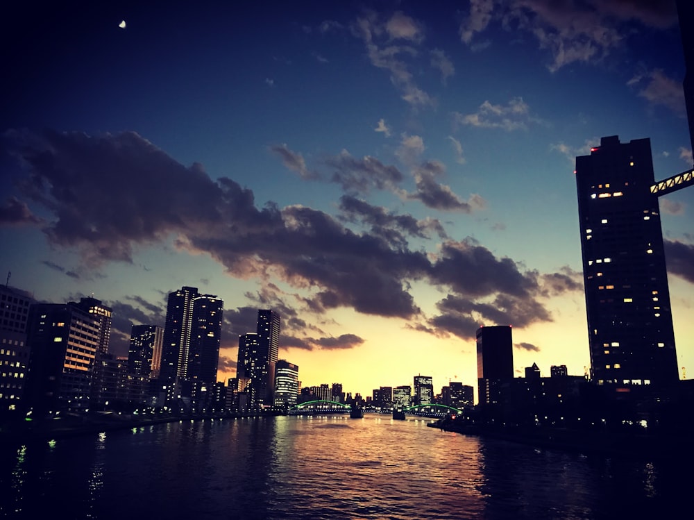 high-rise buildings near body of water taken during sunset