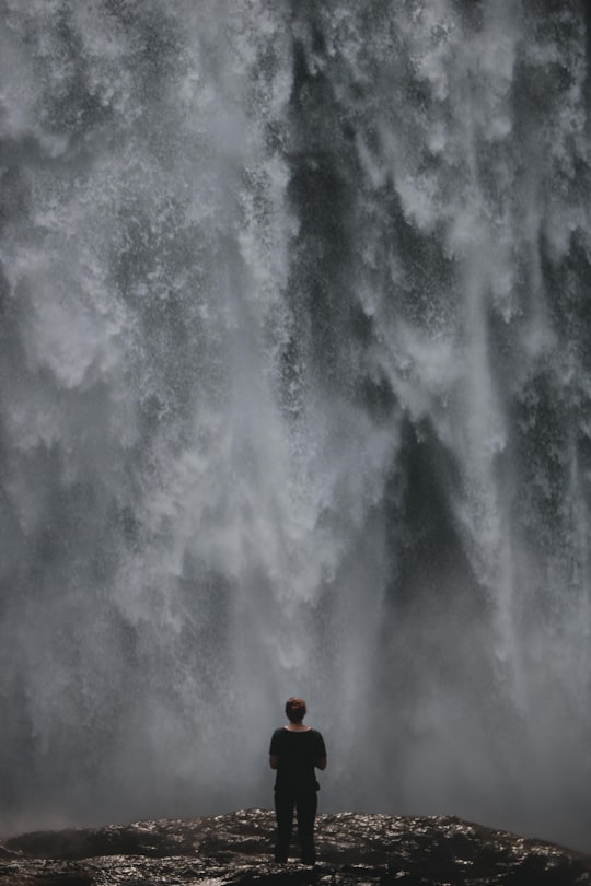 woman standing in front of waterfalls during daytime in Georgia United States