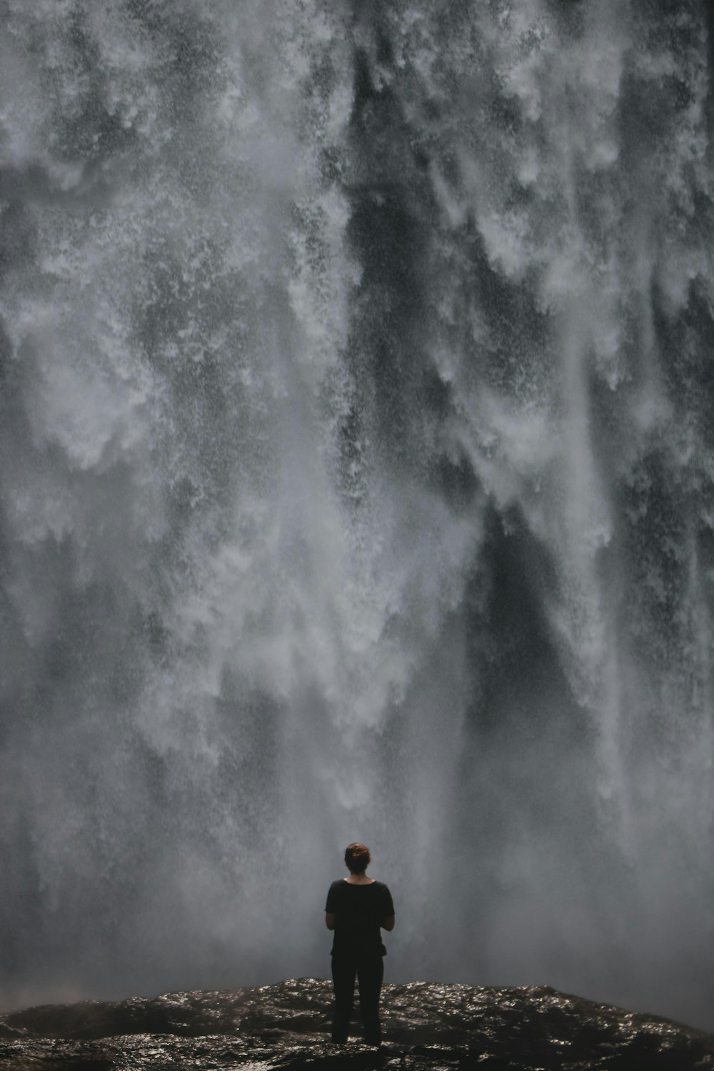 woman standing in front of waterfalls during daytime