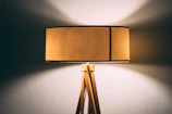 A stylish modern lamp with a handcrafted wooden base casting warm light.