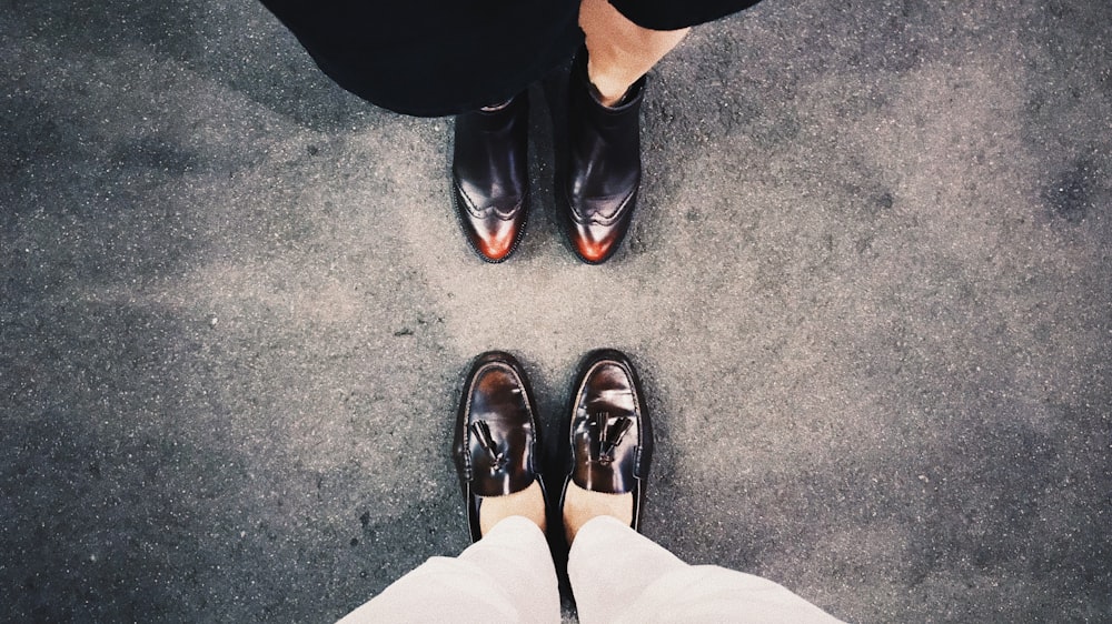 two person standing wearing black loafers