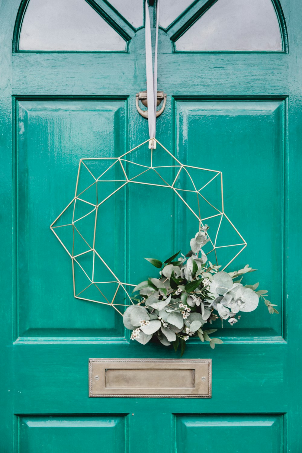 white hanging wreath on green door