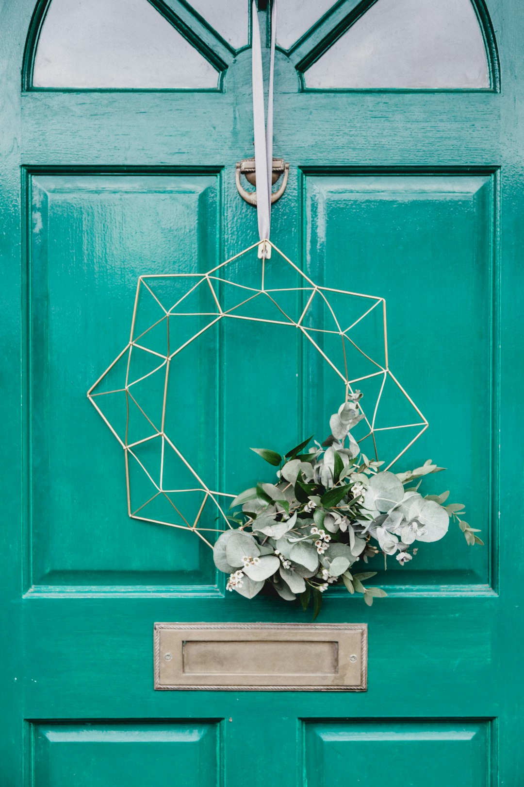 white hanging wreath on green door