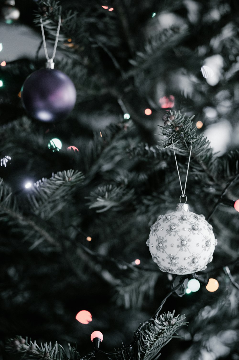 close-up photography of two purple and gray Christmas baubles