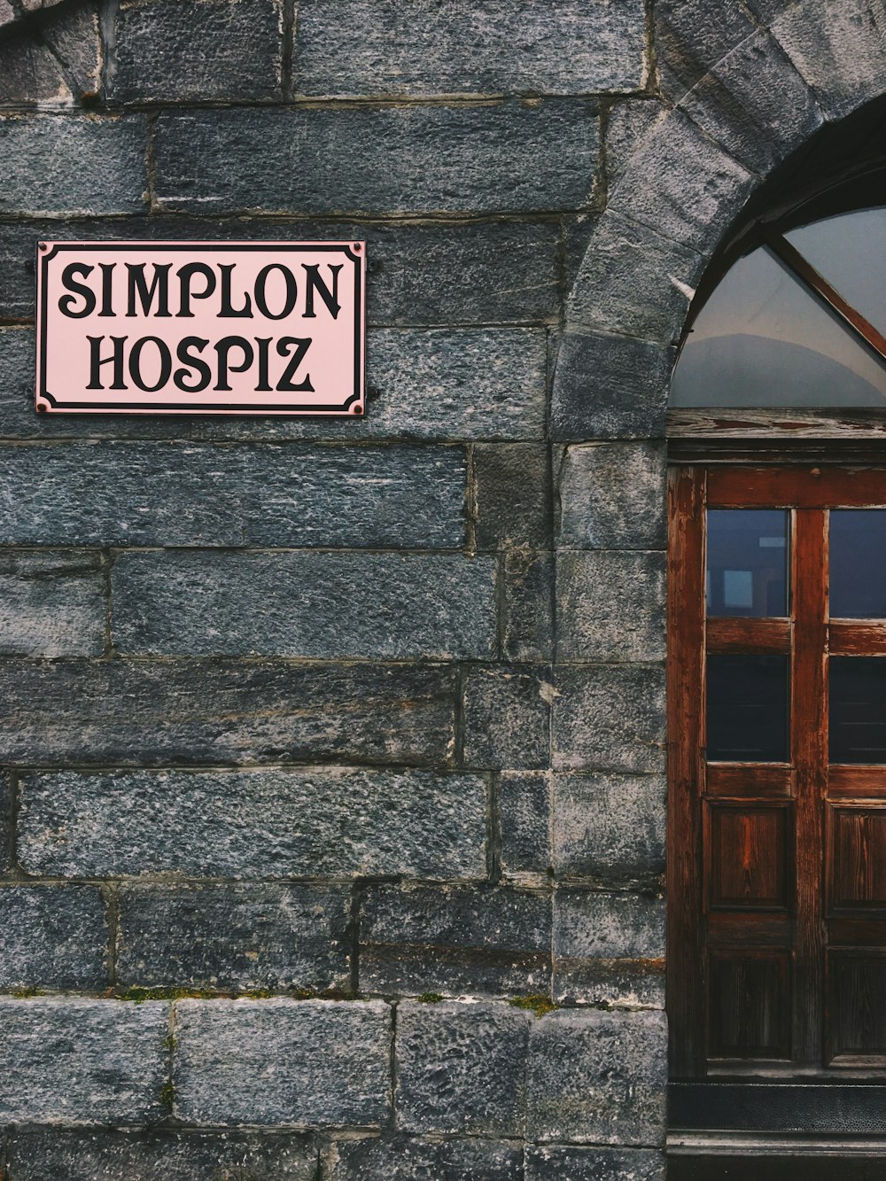 beige Simplon Hospiz signboard on wall