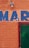 An orange brick wall with the letters 'MAR' painted in blue. A green door is partially visible on the right side, framed in red. There is also a light fixture above the letters.