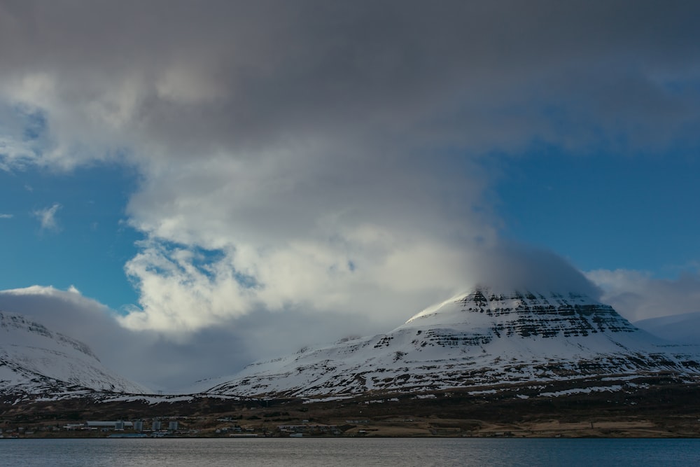 snow covered mountain under cloudy sky