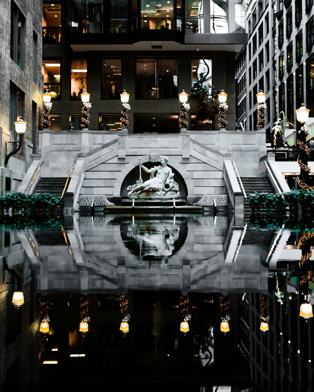 Fotografie eines Gewässers, das zu einer Statue und einem Gebäude führt