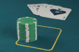 Close-up of casino chips and bonus cards on a green felt table.