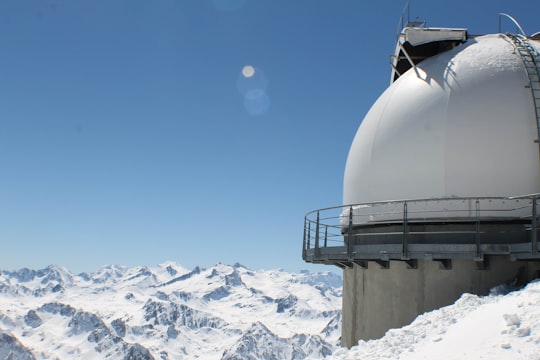 round white building structure in snow capped mountain in Pic du Midi de Bigorre France