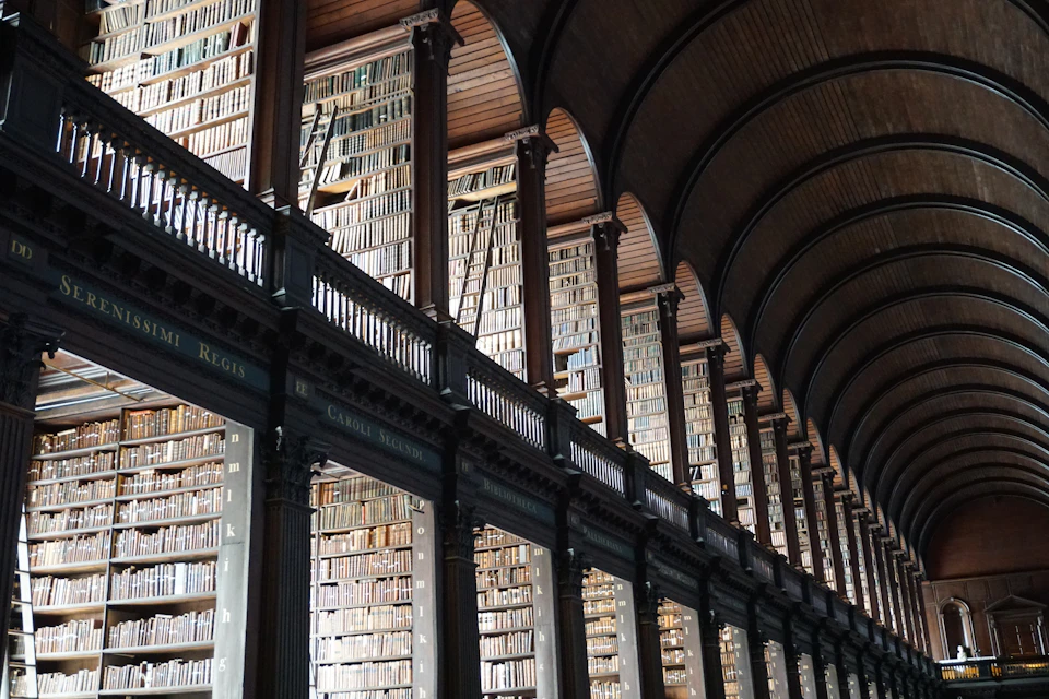 Grand library with high ceilings and arched windows filled with rows of bookshelves
