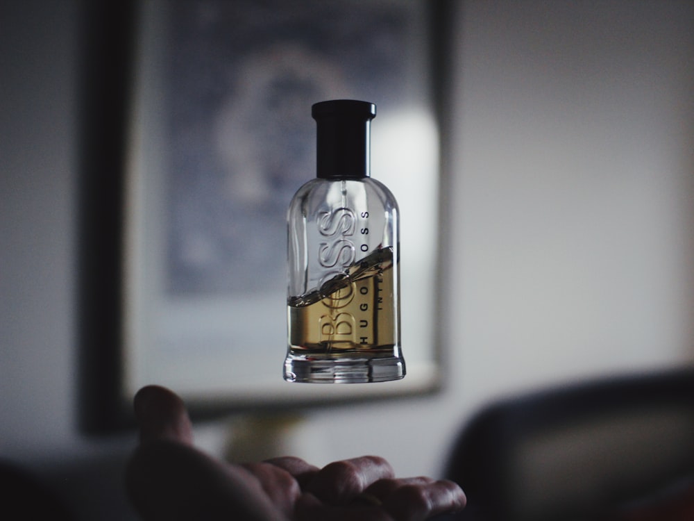 Fotografía de enfoque superficial de frasco de perfume flotante