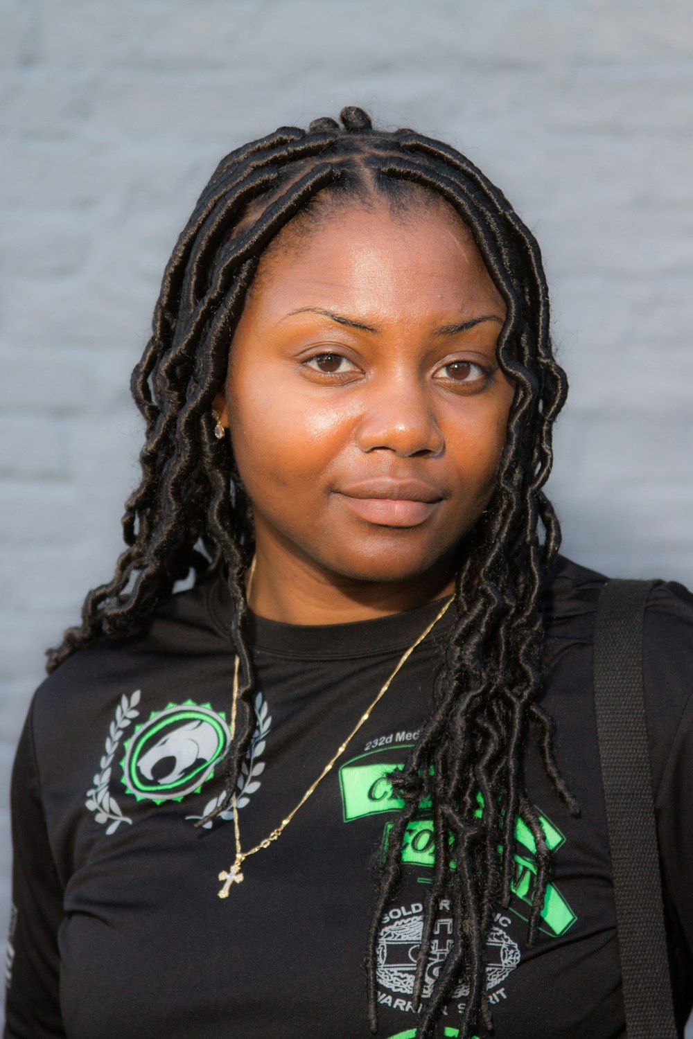 portrait photography of woman wearing black shirt and gold necklace