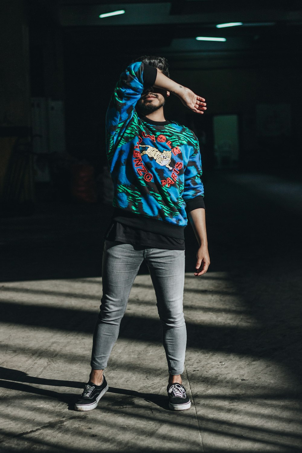 man standing while wearing jacket and denim jeans