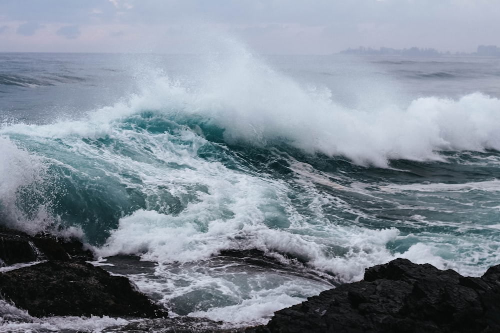 ocean waves hitting rock in beach