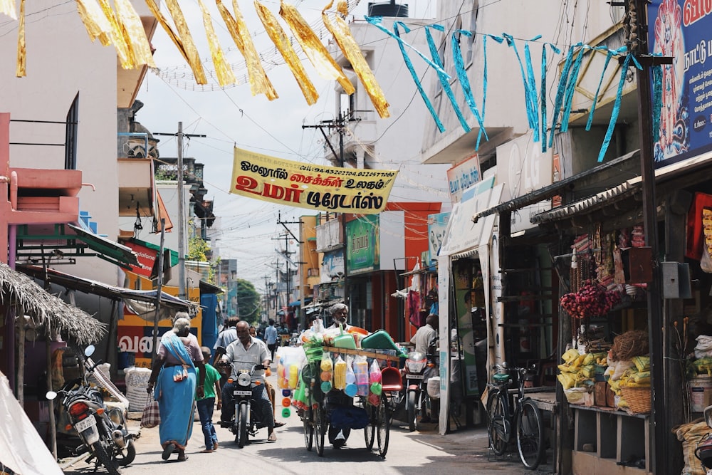 people walking in narrow street with full of food stalls during daytime