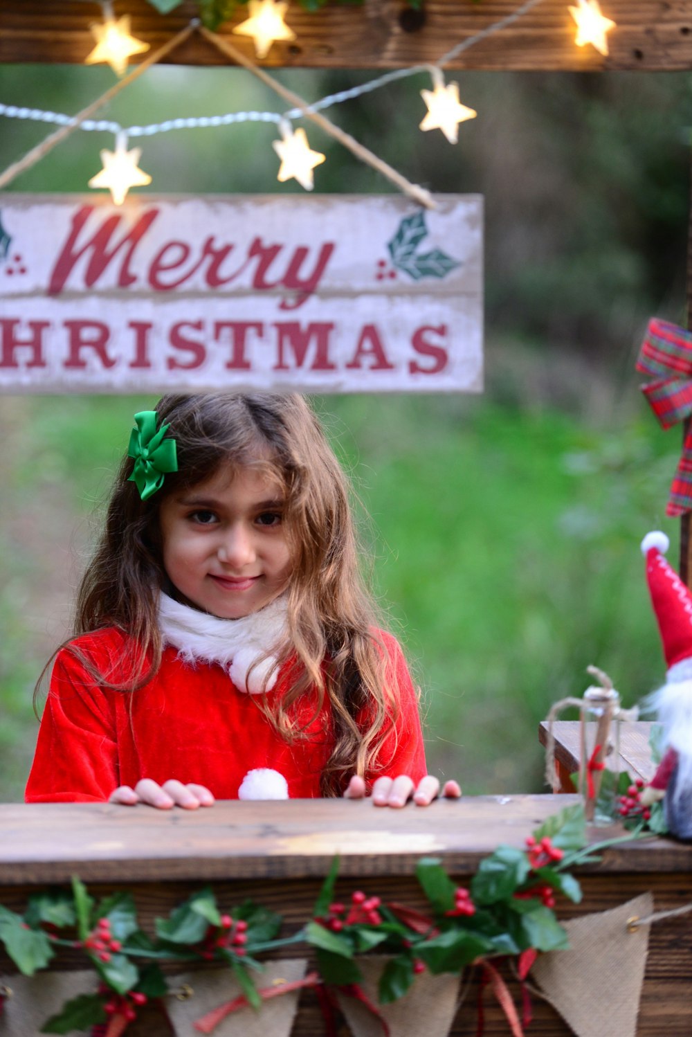 girl standing near merry christmas signage during daytime