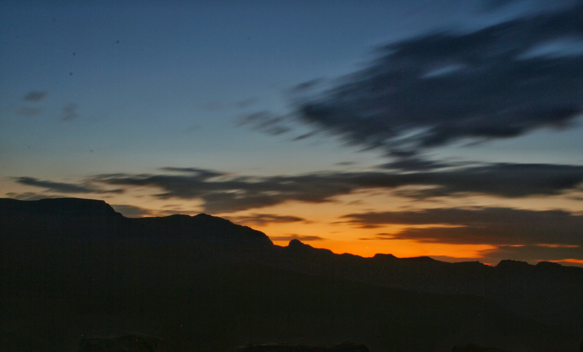A vibrant sunset over a mountain range, capturing the rich colors and dramatic shadows from a recent trip.