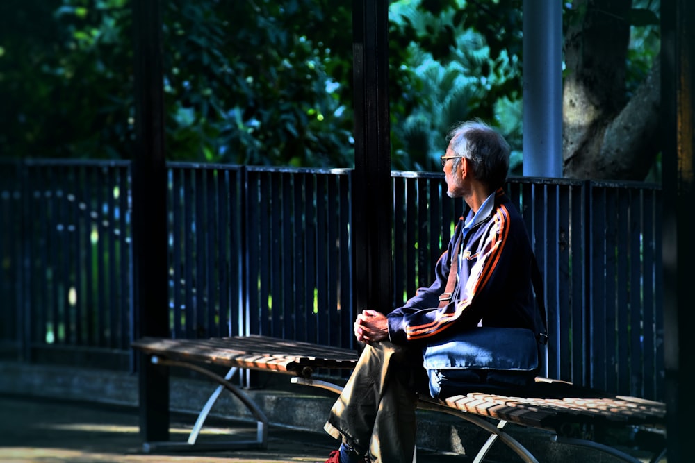 Mann sitzt auf Holzbank