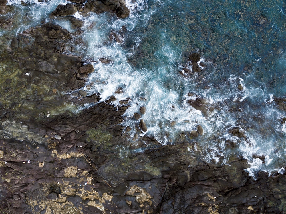 brown cliff near body of water at daytime