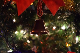 Close-up of a traditional brass bell with soft bokeh lights in the background.
