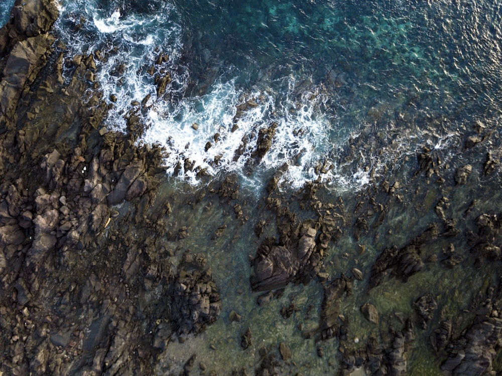 bird's eye view photo of rocks near body of water