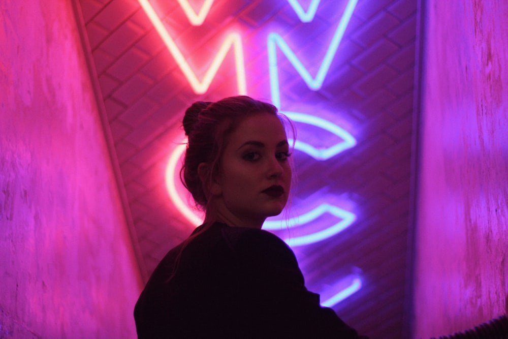 woman wearing black top standing near lighted signage