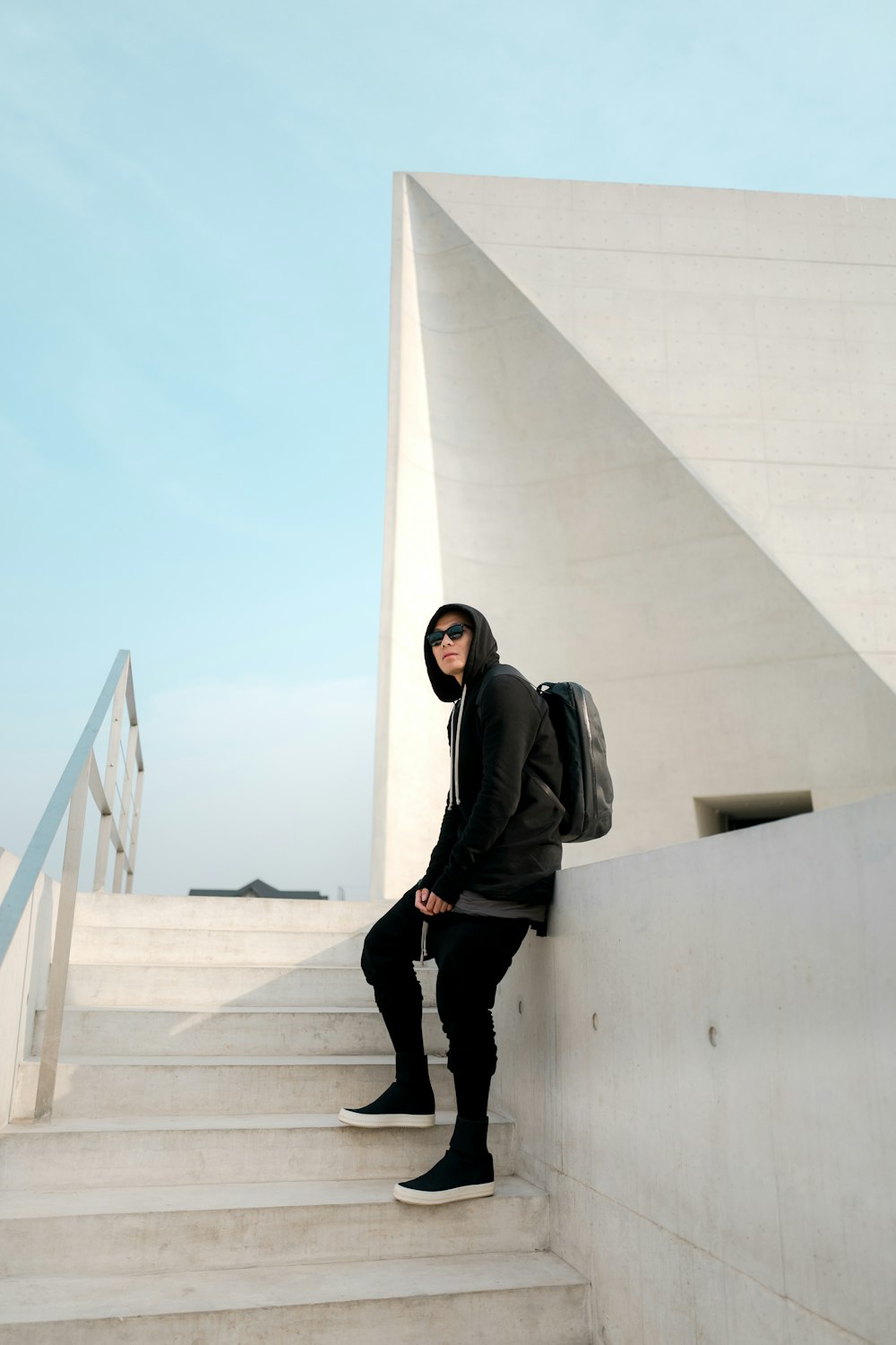 man leaning on white deck while standing in stairway