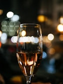 bokeh photography of clear long-stem wine glass