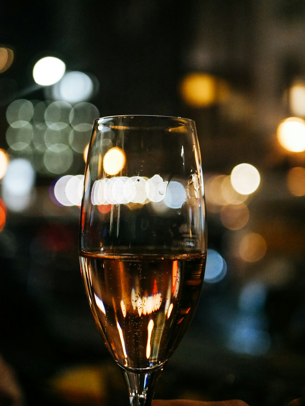 Fotografia bokeh di un bicchiere da vino a stelo lungo trasparente