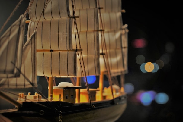 A close-up of intricate details on a wooden model ship's sail.