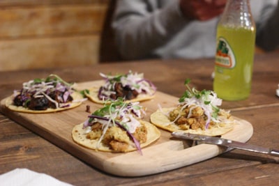 board of four soft tacos on table taco google meet background