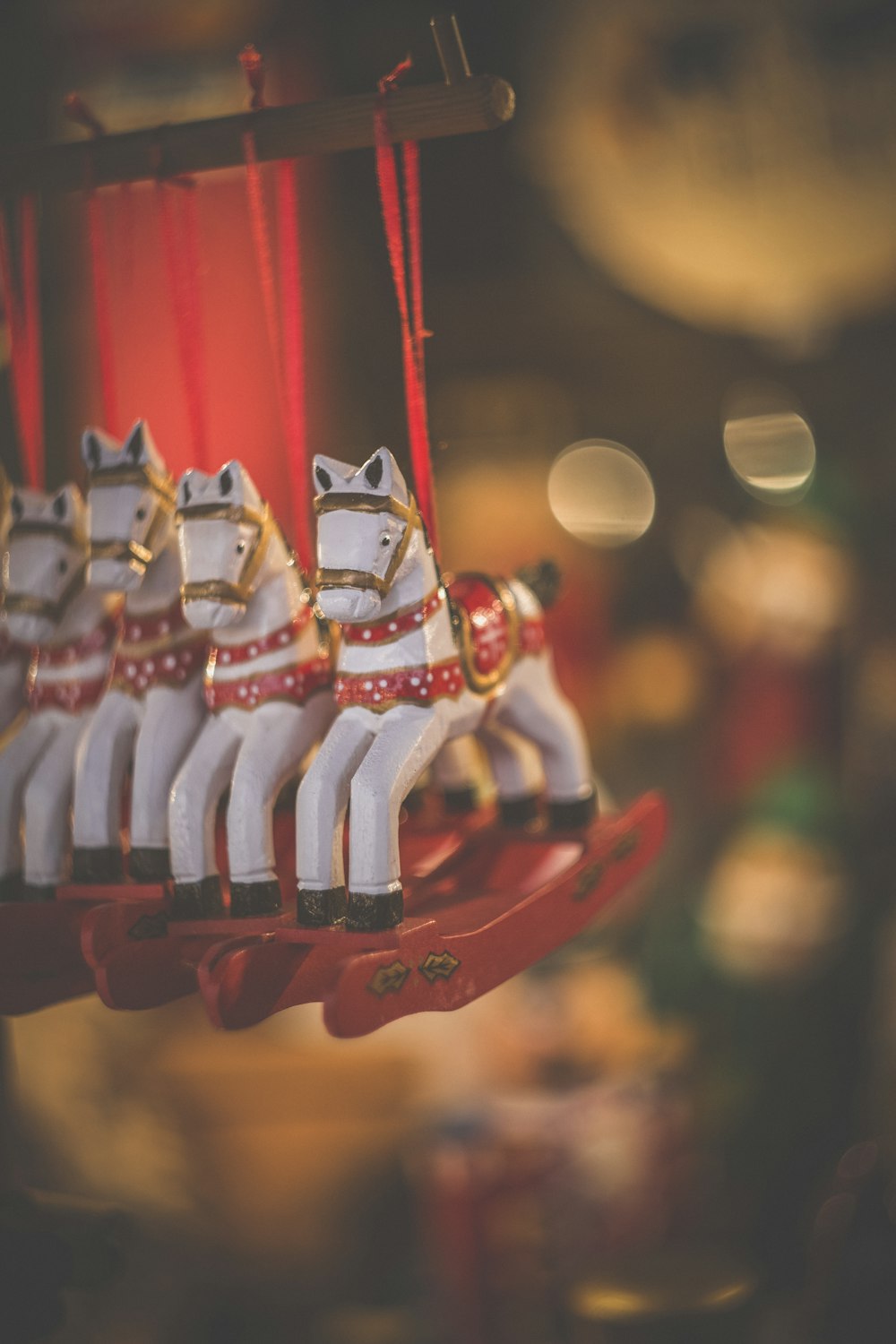 selective focus photography of four horse carousel hanging inside the room