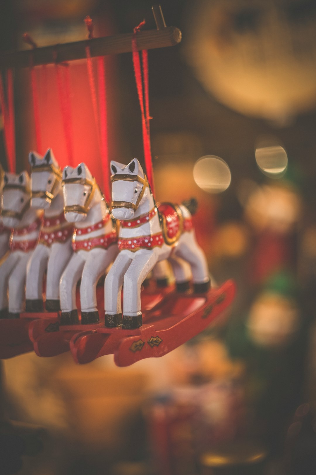 selective focus photography of four horse carousel hanging inside the room