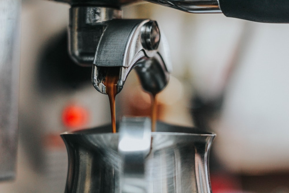 close-up photography of coffee being poured on kettle
