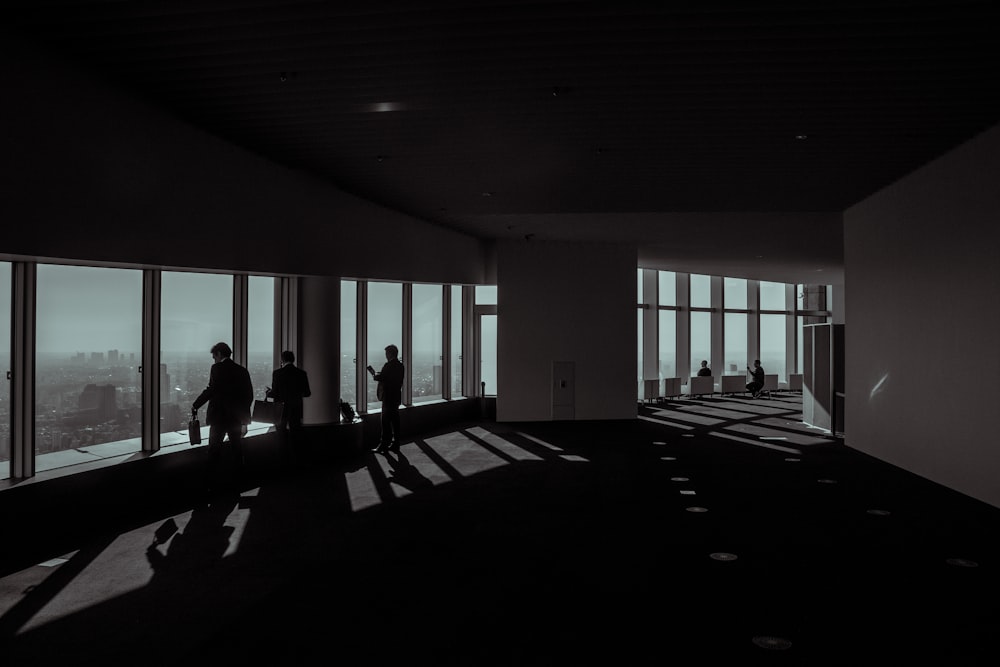 three people standing beside glass window