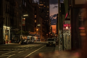 An urban street scene captured at dusk, highlighting the textures and stories of the neighborhood