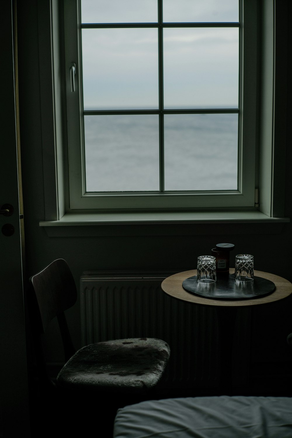 round brown wooden table near window