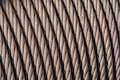 Close-up view of coiled steel cables arranged in parallel, showcasing the intricate twisting and texture of the metal strands. The image highlights the durability and strength of the cables.