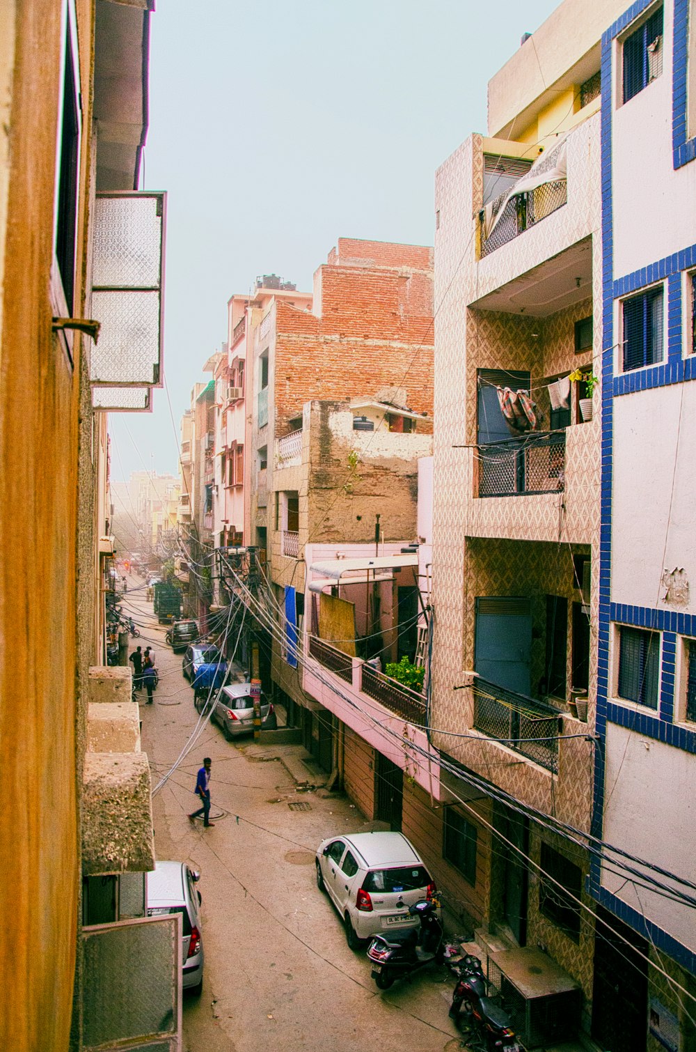 vehicles and people on road between buildings