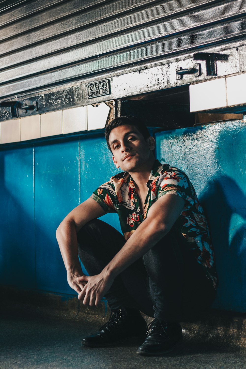 man sitting on ground leaning on wall