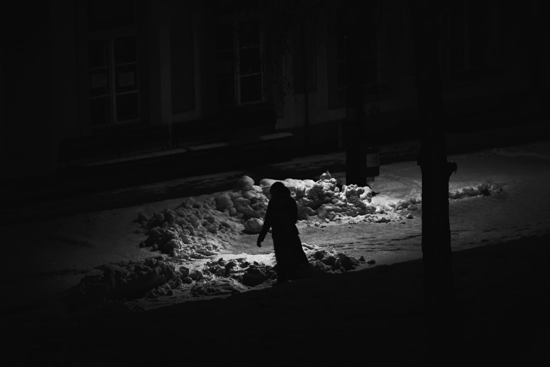 grayscale photography of person waling on street